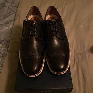This pair of Cole Haans Grand OS shoes are black with white bottoms size 12